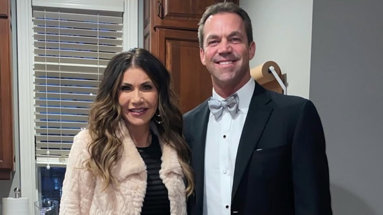 Kristi and Bryon Noem smiling in formal attire in a kitchen