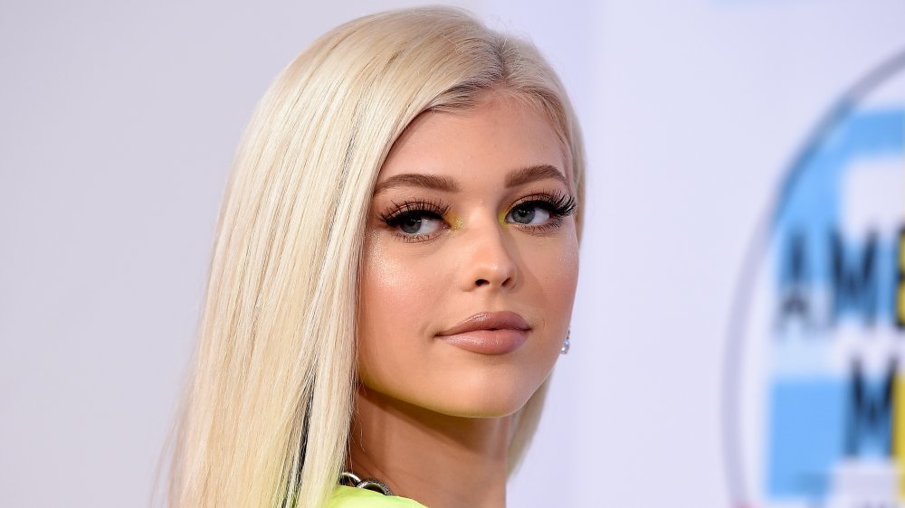 Loren Gray in a yellow dress, looking over her shoulder