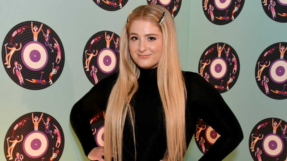 Meghan Trainor in front of a wall with records