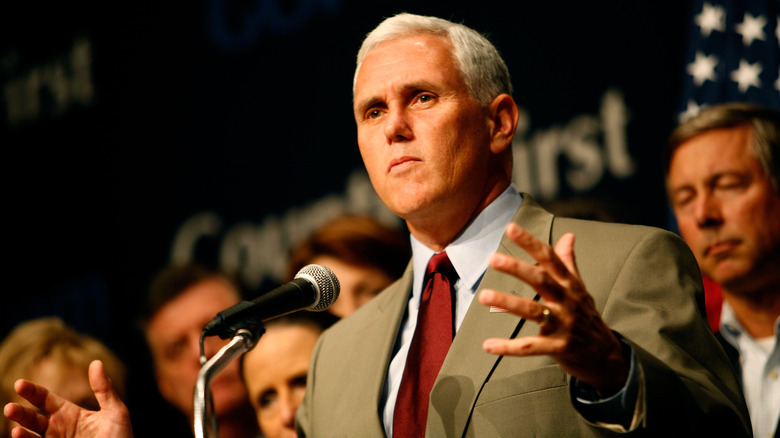 Mike Pence speaking at podium with arms out