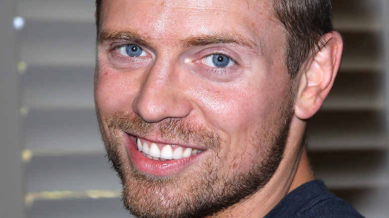 Mike Mizanin in front of blinds