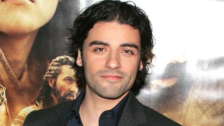 Oscar Isaac in front of a movie poster