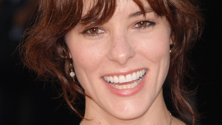 Parker Posey smiling with bangs