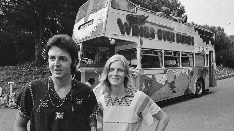Paul McCartney and Linda McCartney, standing in front of double decker bus