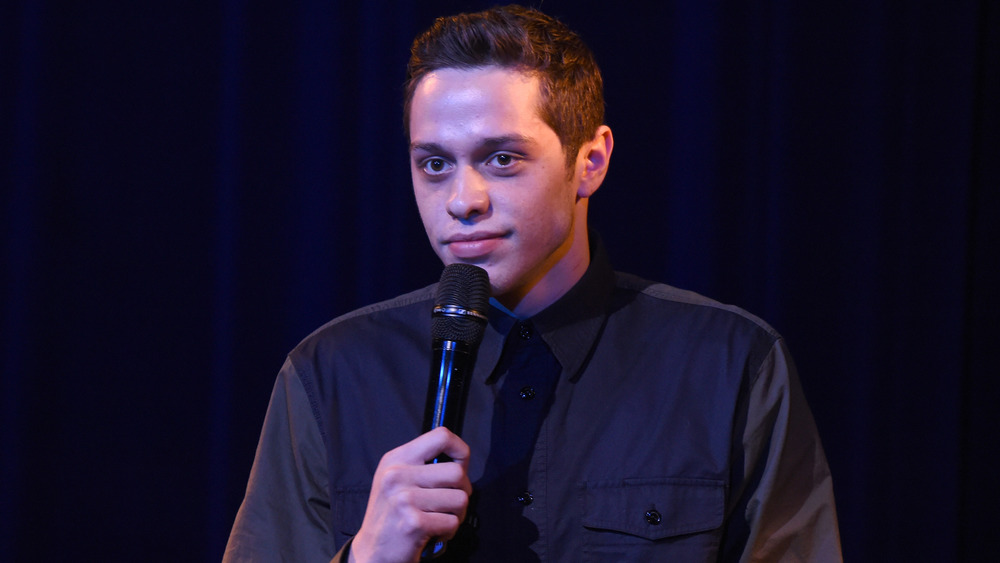 Pete Davidson holding a microphone 