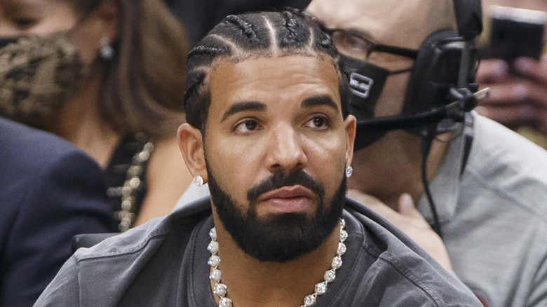 Drake looking away, seated