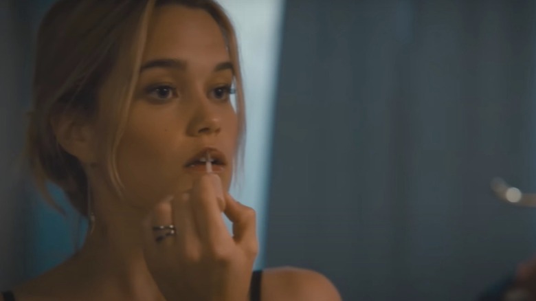 Sarah Catherine Hook putting on lipstick in a scene from Cruel Intentions