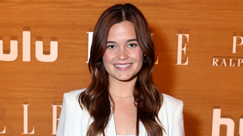 Sarah Catherine posing in front of a light brown background