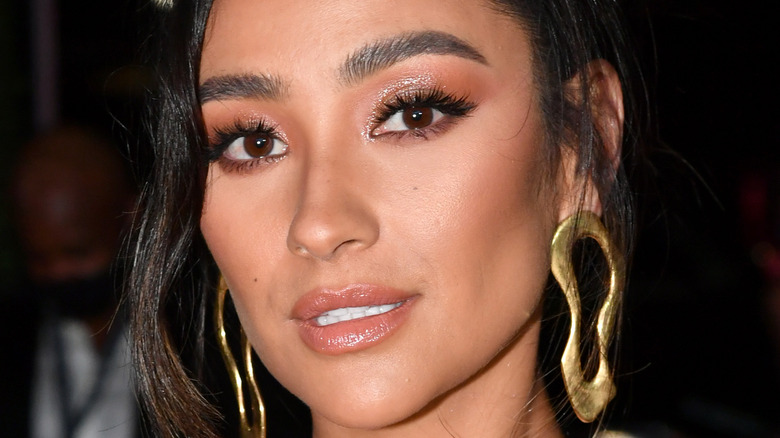 Shay Mitchell smiling gold earrings