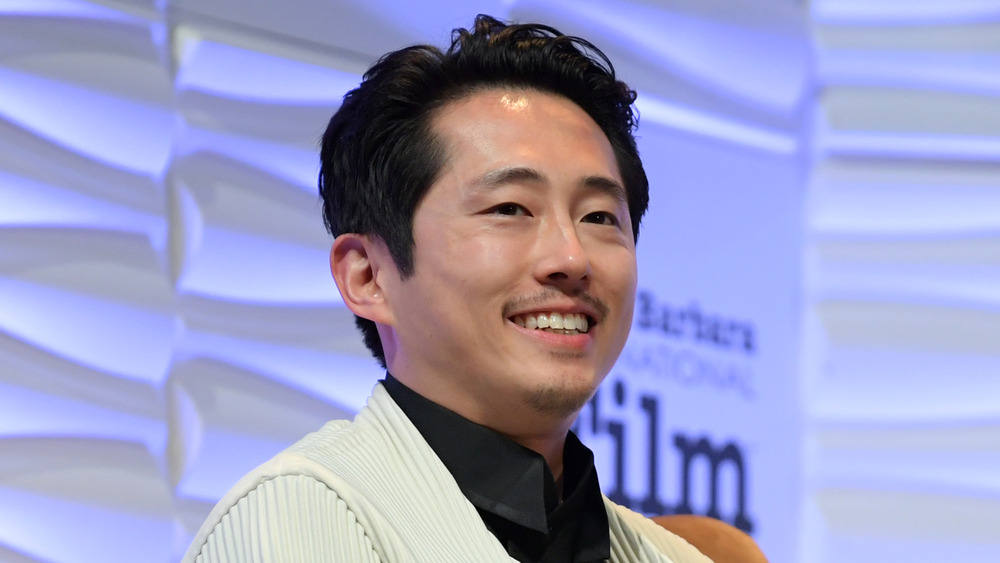 Steven Yeun smiling on stage