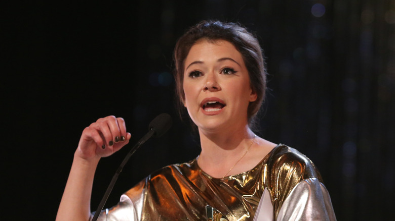 Tatiana Maslany talking in silver and gold outfit