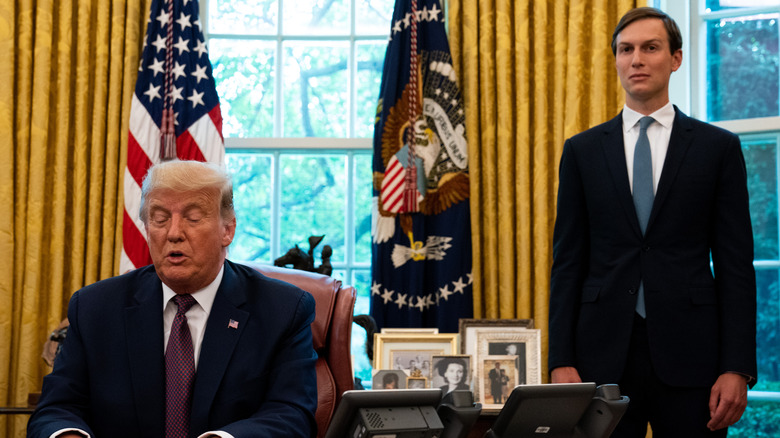 Jared Kushner standing behind Donald Trump in Oval Office