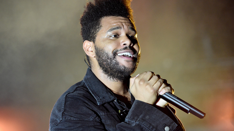 The Weeknd smiling while singing