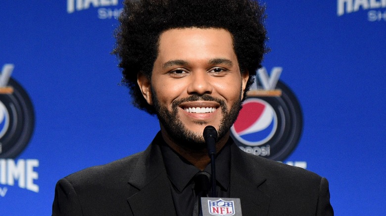The Weeknd laughing in suit