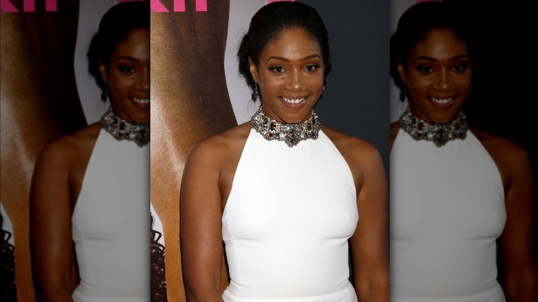 Tiffany Haddish smiling in her white Alexander McQueen dress