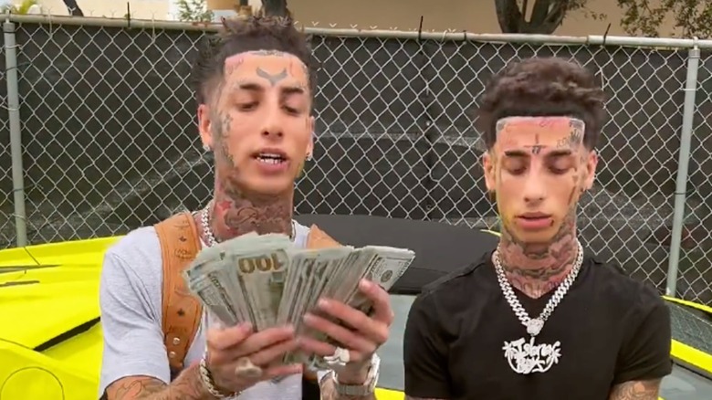The Island Boys holding wads of cash