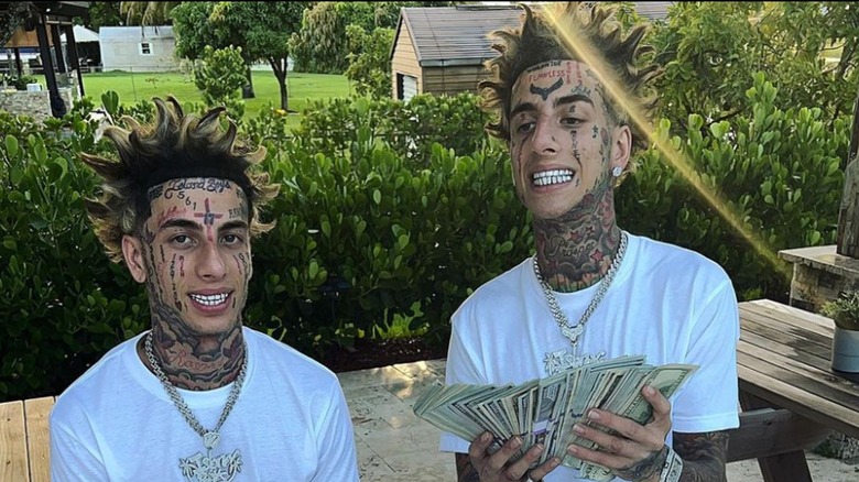 The Island Boys smiling and posing with a wad of cash