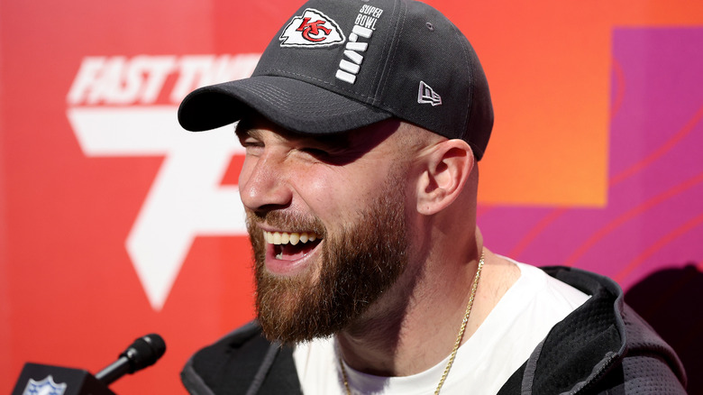 Travis Kelce talking into a microphone