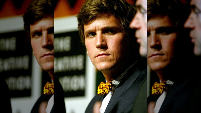 Tucker Carlson glancing off to the side with an unhappy expression