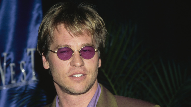 Val Kilmer, smirking and striking a pose on the red carpet