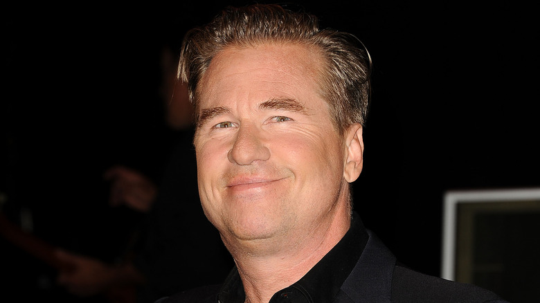 Val Kilmer, smiling while posing at an event