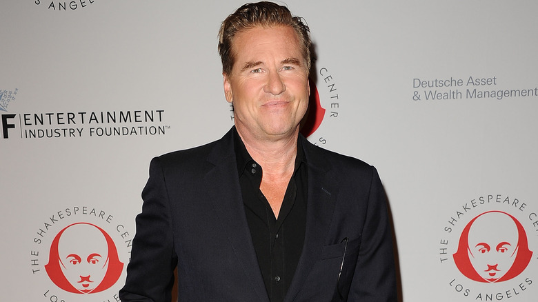 Val Kilmer, wearing an all-black outfit and posing at an event
