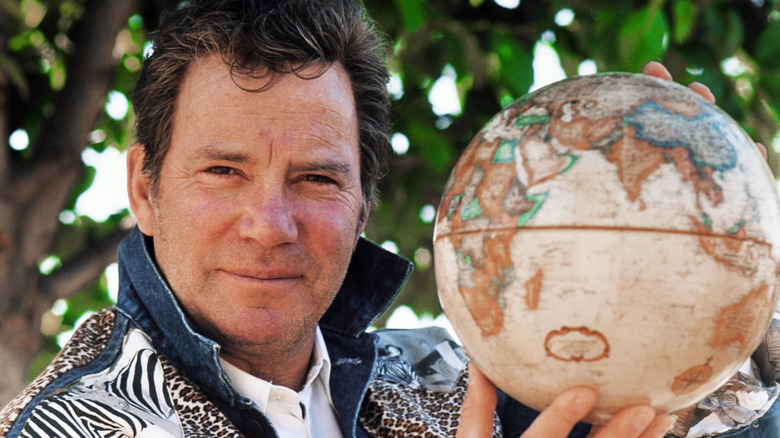 William Shatner holding a globe
