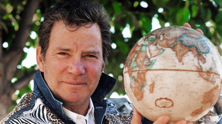 William Shatner holding a globe