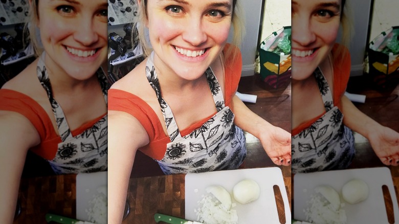 Kelly Kristofferson displays her sunflower apron with a big smile.