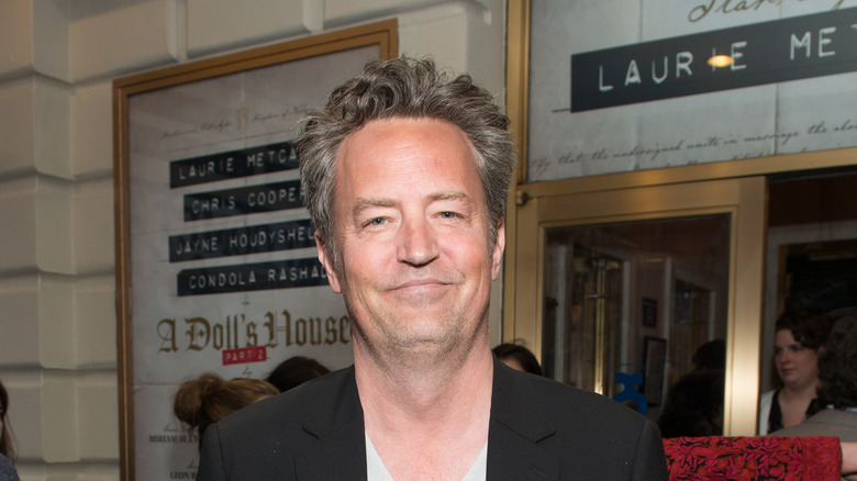 Matthew Perry wearing a black suit jacket
