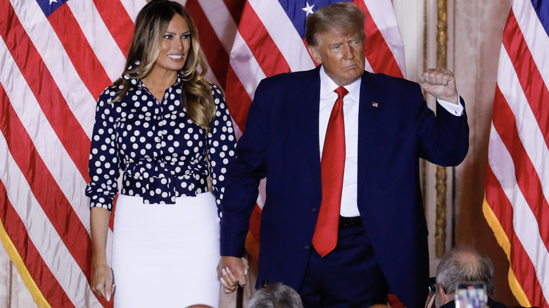 Donald and Melania Trump in front of flags