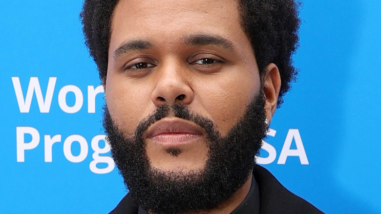 The Weeknd smirks on the red carpet