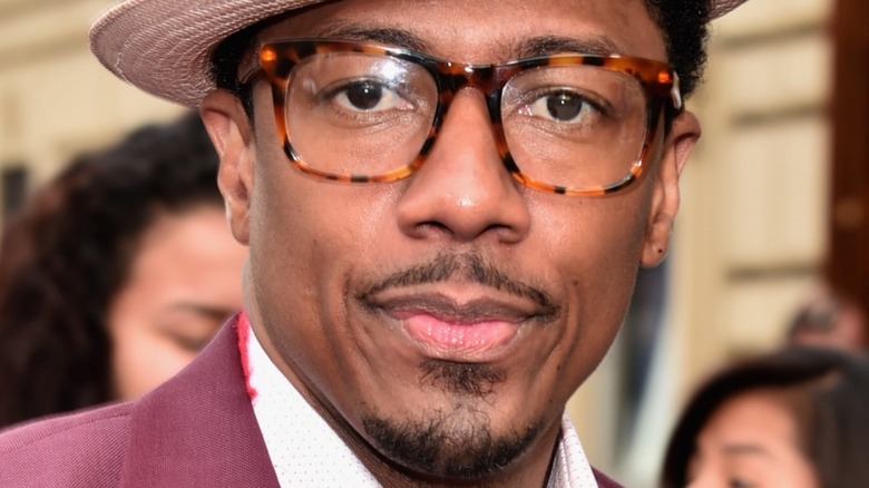 Nick Cannon wearing fedora and glasses