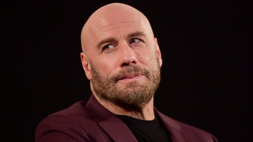John Travolta looking intense with bald head and beard 