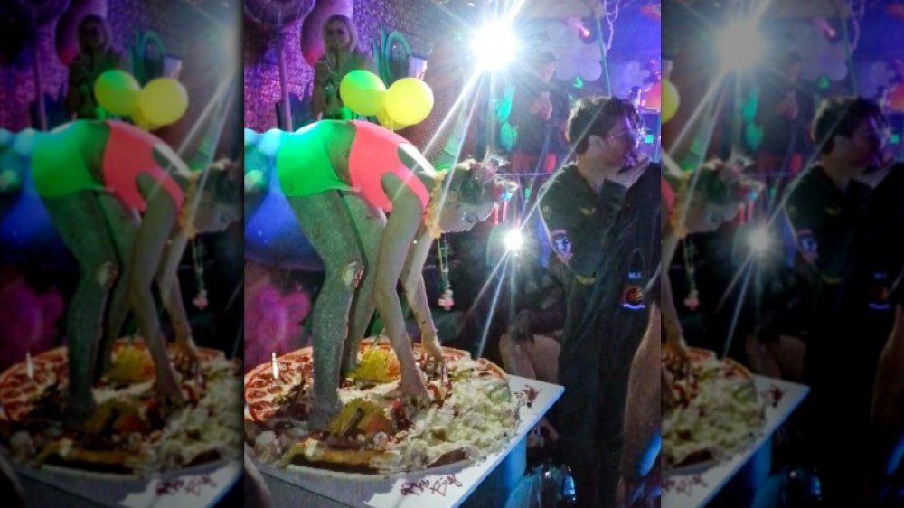 Miley Cyrus standing on her pizza cake at her 22nd birthday party