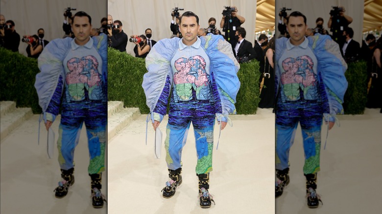 Dan Levy wearing a puffy-sleeved outfit with two men kissing at the 2021 Met Gala.