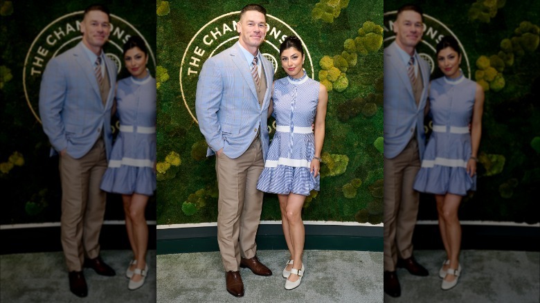 John Cena wearing blue blazer and posing with Shay Shariatzadeh, who is wearing a blue dress, at Wimbledon 2025