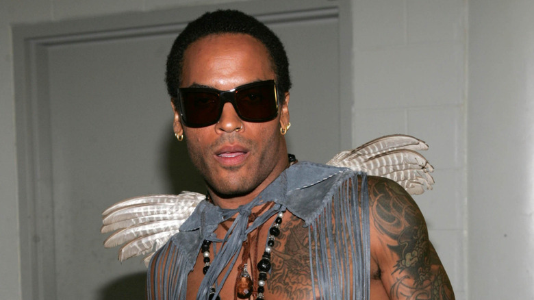 Lenny Kravitz wearing a fringed denim shoulderpiece with mini angel wings.