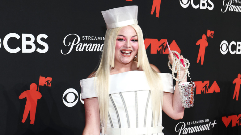 Megan Stalter wearing a cup-inspired gown with a bedazzled Dunkin' Donuts cup purse.