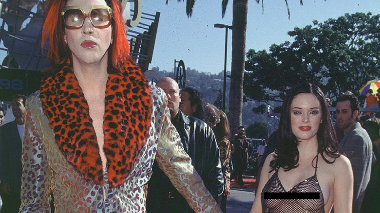 Rose McGowan wearing a see-through mesh dress while walking hand in hand with Marilyn Manson.