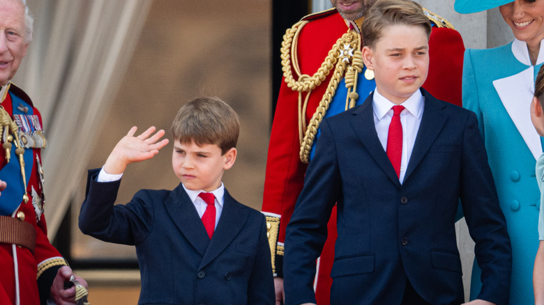 Princes George and Louis wearing blue suits and red ties at Trooping the Colour 2025
