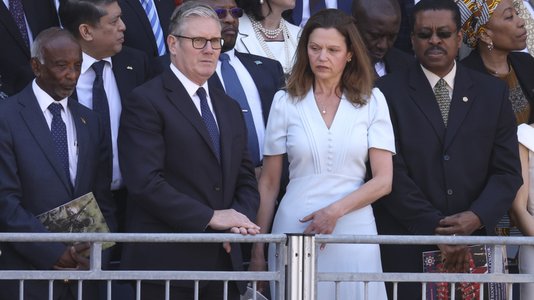 Lady Victoria Starmer wearing a frumpy white dress and looking miserable