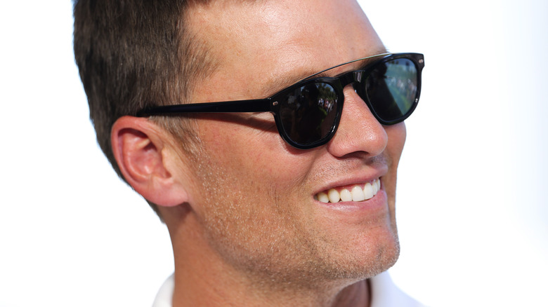 Tom Brady smiling, wearing sunglasses