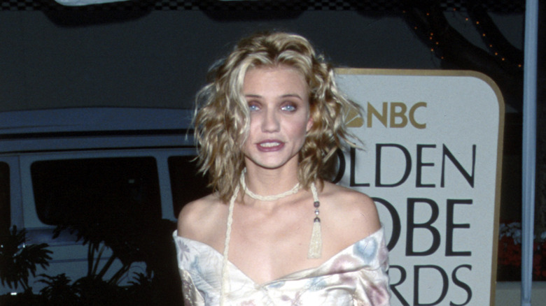 Cameron Diaz wearing a white floral strapless gown with a thin scarf around her neck