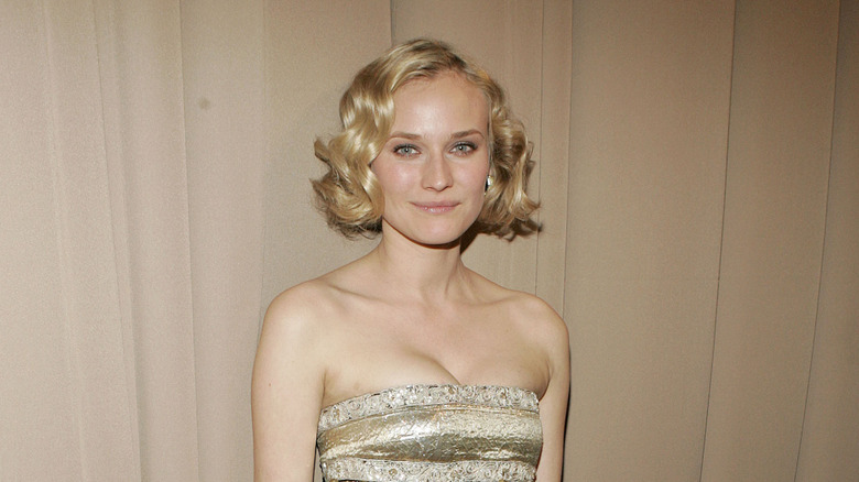 Diane Kruger wearing a gold strapless gown with a dark gold bodice that leaves her hips bare