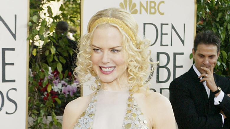 Nicole Kidman wearing a gold sparkling scarf headband and gold sequined halter dress