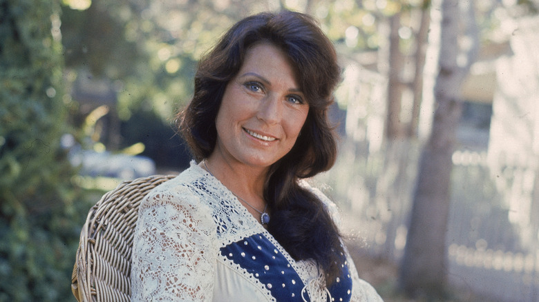 Loretta Lynn, sitting alone outside, 1970s photo