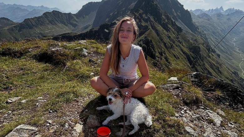 Lady Marina Windsor seated on a mountain with a dog.