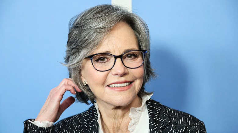 Sally Field touching her shorter hair on the red carpet.