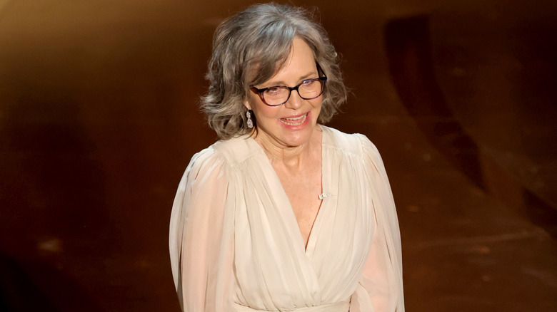 Sally Field on stage at the 2024 Academy Awards in a white dress with a deep V-neck.